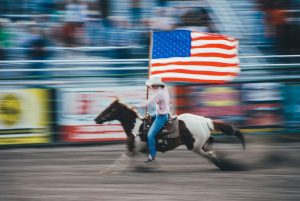 A person on a horse with the American Flag